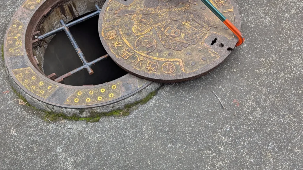 An opened manhole cover of a fire-fighting water tank during a neighborhood disaster-prevention inspection