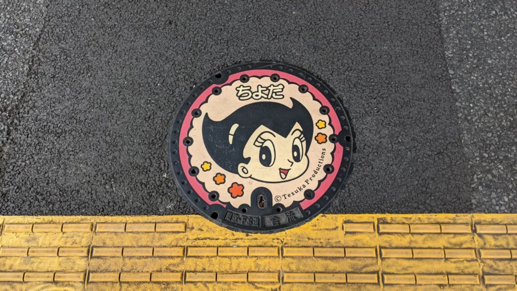 Colorful Chiyoda (Tokyo) sewer cover with a Tezuka Productions character