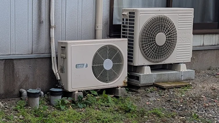 A rare right-eye outdoor air conditioner unit (fan on the right) next to a modern left-eye unit