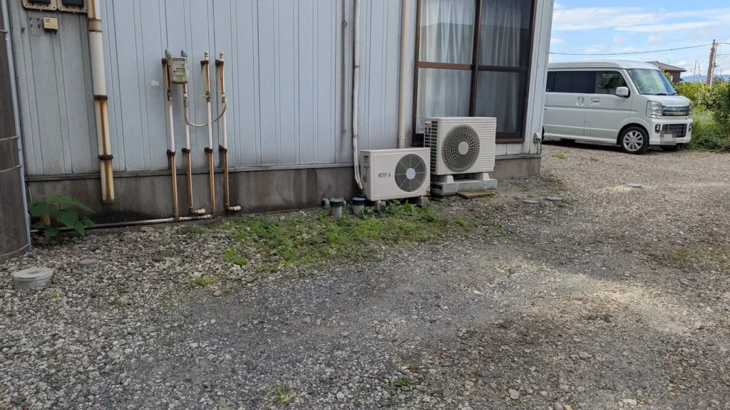 A right-eye outdoor unit next to a left-eye unit beside an office building